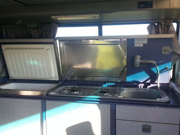 Nevera o congelador,  cocina de butano y fregadero. 